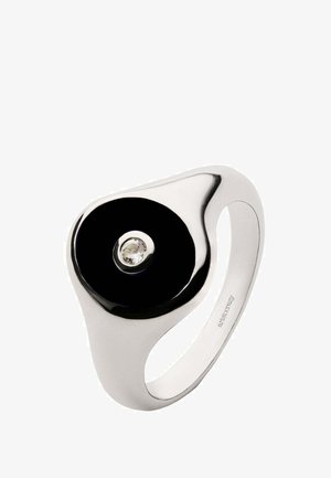 Anillo de plata con un centro circular negro brillante y una piedra preciosa clara en el centro. Diseño suave y curvado con un acabado pulido.