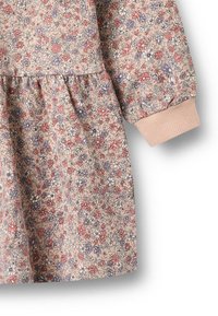 Abito con stampa floreale in morbido tessuto beige. Presenta maniche a sbuffo, vita arricciata e polsini a costine in una tonalità di rosa chiaro.