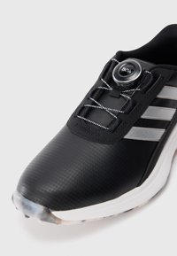 Black athletic shoe with a smooth, textured upper, featuring silver stripes, a BOA lacing system, and a white sole with a rubber outsole.