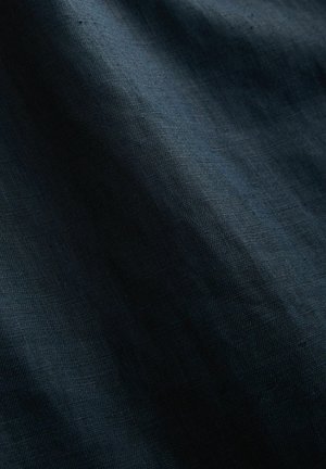 Tumehall sinine tekstureeritud kangas, pisut kortsus ja siledal pinnal. Keskmise kaalu ja peene läikega, millel on detailne kudumismuster.
