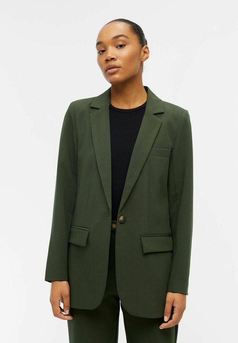 Dark green blazer with structured shoulders, single button closure, two front pockets, and soft, smooth fabric texture.