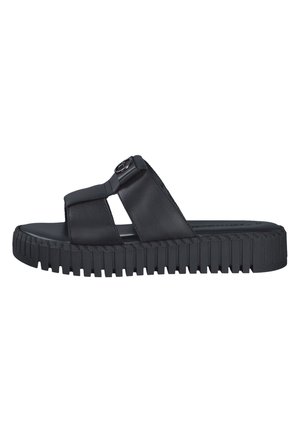 Black slip-on sandal with a wide strap, smooth leather material, thick rubber sole with a textured pattern, and an emblem detail on the strap.