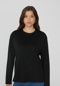 Schwarzes Langarmshirt mit rundem Halsausschnitt, aus weichem Stoff gefertigt, mit locker sitzenden Ärmeln und geradem Saum.