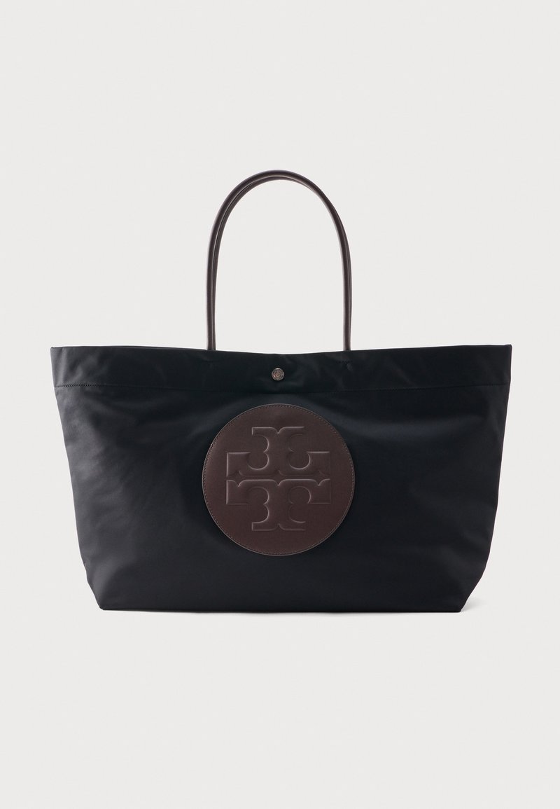 Sac fourre-tout noir avec de longues anses et un grand emblème circulaire brun embossé d'un motif symétrique au centre avant.