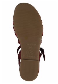 Sandalia roja con suela de goma marrón texturizada, con un logo de la marca y correas ajustables. Fabricada en España, con un diseño plano y sin adornos.