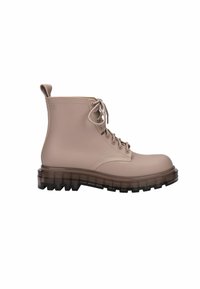 Botas de tobillo impermeables beige con puntera redonda, cordones en la parte delantera y una suela de goma negra gruesa y texturizada para mayor tracción.