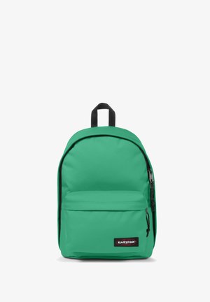 Grøn stof rygsæk med en front lynlåslomme, rund form, sort lynlås og mærket label i bunden. Enkel design, struktureret materiale.