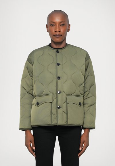 Olive green quilted jacket with a round neck, front button closure, and two large pockets. Soft texture with scalloped pattern.