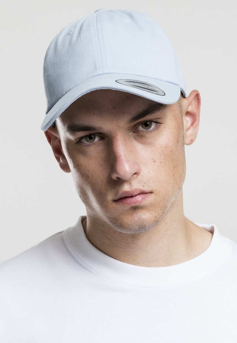 Cappellino da baseball azzurro chiaro con visiera curvata e occhielli ricamati. Indossato da un modello in una maglietta bianca a girocollo.