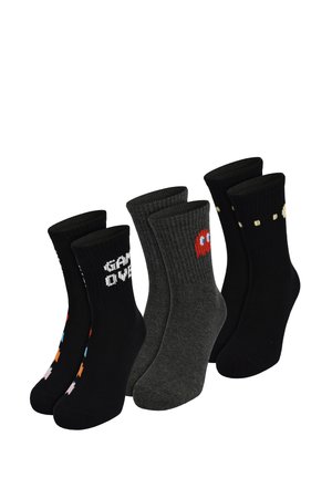 Three pairs of mid-calf socks with retro video game designs: black with "GAME OVER," gray with red ghost, and black with yellow dots.