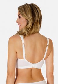 Biały stanik z regulowanymi ramiączkami, gładką teksturą i zapięciem na haczyk, prezentujący minimalistyczny design i czyste linie.