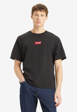 Sort bomulds T-shirt med rund hals, korte ærmer og et rødt Levi's logo patch på brystet. Bruges sammen med blå denim jeans.