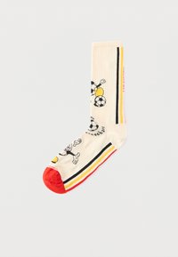 Κρεμ κάλτσα με κόκκινη μύτη, μαύρες, κίτρινες και κόκκινες ρίγες, με καρτούν σκύλο που παίζει με ποδοσφαιρικές μπάλες και κείμενο στο πόδι και το πόδι.