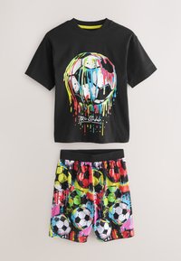 Sort t-shirt med farverig dryppende maling fodbold og teksten "Pro Striker", kombineret med multifarvede shorts med fodboldtryk.