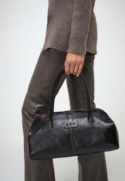 Borsa a mano in pelle nera di forma arrotondata, con due manici robusti e una superficie testurizzata. Presenta un logo del marchio impresso sul fronte.
