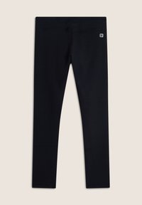 Leggings neri con un motivo testurizzato a nido d'ape, vita elasticizzata e patch con logo sul lato sinistro anteriore. Tessuto morbido, design a lunghezza intera.