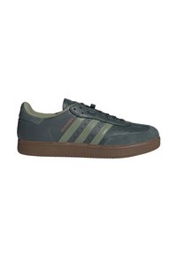 Baskets Adidas Velosamba vert foncé avec semelle en gomme, trois bandes olive, bout perforé et logo doré sur le côté.