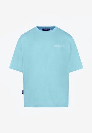 Camiseta de manga corta de color azul claro con texto "PEQUS MYKONOS ©2017" en el pecho izquierdo y una pequeña etiqueta azul en la costura lateral izquierda.
