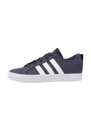 Marineblauwe lage sneaker met witte strepen, vetersluiting, gevoerde kraag en witte rubberen zool tegen een witte achtergrond.