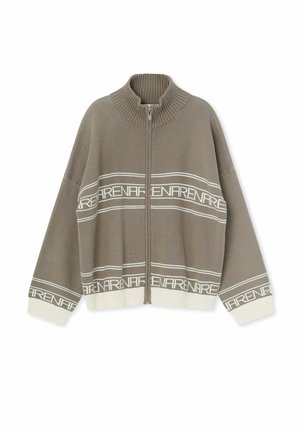 Taupekleurig gebreid vest met witte geribde kraag, manchetten en zoom, voorzien van witte horizontale strepen en herhalende "ARENA"-tekstpatronen, met ritssluiting aan de voorkant.