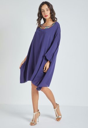 Vestido morado, holgado, con cuello redondo, adornado con un diseño de cuentas coloridas, hecho de una tela ligera.