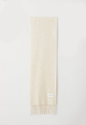 Écharpe beige douce avec des extrémités effilochées et une petite étiquette blanche portant la mention "Marc O’Polo" près d'un bord sur un fond blanc.