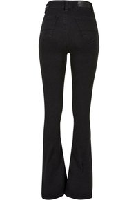 Jean en denim noir taille haute avec jambes évasées et poches arrière, vu de dos sur fond blanc.