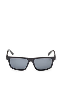 Lunettes de soleil à monture rectangulaire noire avec verres teintés foncés, branches légèrement courbées, présentées sur un fond blanc.