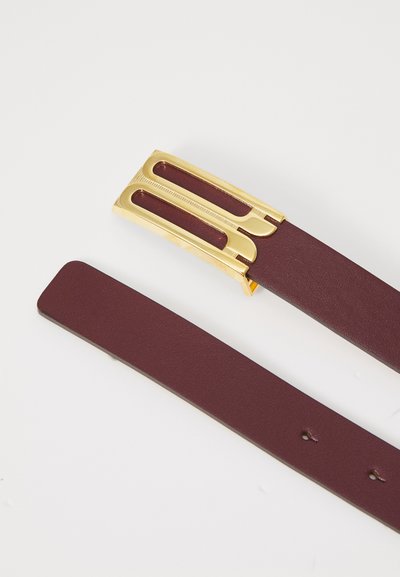 Curea din piele burgundy cu cataramă din metal auriu, cu design decupat și suprafață texturată. Finisaj neted pe banda curelei.