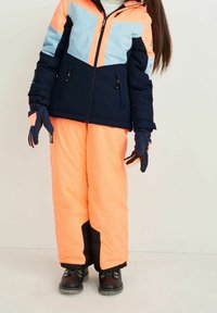 Navy and light blue insulated jacket with orange snow pants. Features include a hood, zippered pockets, and textured gloves with grip.