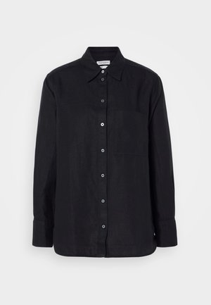 Chemise noire en lin à manches longues avec un boutonnière à l'avant, un col, une poche poitrine unique et des boutons foncés sur un fond uni.