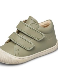 Scarpa in pelle verde con due cinturini in Velcro, forma arrotondata e suola in gomma texture. Interno foderato con materiale di colore chiaro.
