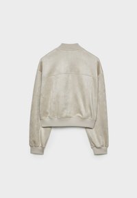 Kort cremefarvet jakke med en glat, fløjlsagtig tekstur; har ribstrikket krave og manchetter samt en afslappet pasform.