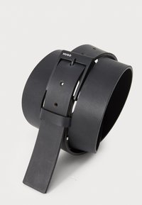 Ceinture en cuir noir avec une finition lisse, dotée d'une boucle rectangulaire et de plusieurs trous d'ajustement. Logo de la marque visible sur la boucle.