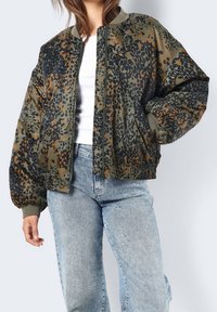 Kurtka bomber w zielonym, czarnym i pomarańczowym nadruku w panterkę. Posiada elastyczne mankiety i dół, zamek błyskawiczny oraz luźny krój.