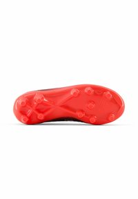 Soccer cleat sole in red rubber with six molded studs; textured surface and intricate design pattern for traction and stability.