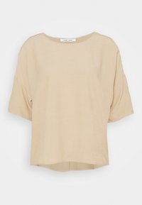 Beige kortärmad topp med rund halsringning, mjuk textur och en något lös passform. Har en rundad fåll i nederkant.