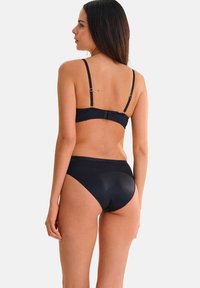 Zwarte bikini-set met een gladde textuur, verstelbare bandjes en een hoge taille broekje. Het ontwerp benadrukt een klassieke uitstraling.