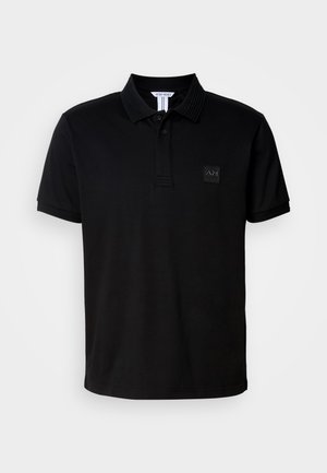 Black polo shirt made of smooth fabric, featuring a collar with ribbed texture and a small square logo patch on the left chest.