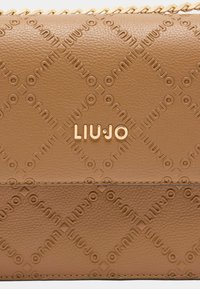 Tasche aus braunem Leder mit geprägtem Logomuster, goldfarbenen Beschlägen und einem gesteppten Design. Die Abmessungen sind kompakt und rechteckig.