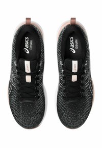 Black athletic shoes with a textured upper, white sole, and subtle pink accents. Features include rounded toe and contrasting laces.