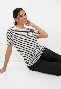 Stripet crew neck t-shirt i lys grå og sort med korte ærmer og en afslappet pasform. Blødt stof med en subtil tekstur.