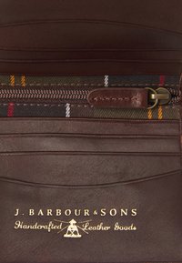Brown leather wallet with a zippered compartment. It features a plaid pattern in earthy tones and gold embossed brand text.