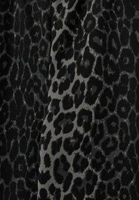 Melna un pelēka leoparda raksta audums, kas iekļauj gan gludas, gan teksturētas virsmas, ar dažādiem leoparda plankumiem izteiksmīgā rakstā.