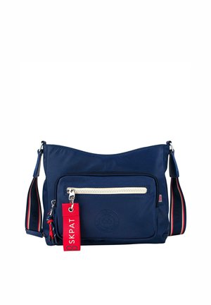 Bolso de nylon azul marino para el hombro con un bolsillo delantero con cremallera, correa ajustable y etiqueta de marca roja. Presenta un detalle de logotipo circular en relieve.
