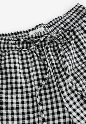 Pantaloni scurți în carouri alb-negru, cu talie elastică, șnur de ajustare și material ușor. Prezintă un model mic de carouri pe toată suprafața.
