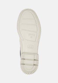 Suela de un zapato gris mostrando caucho blanco texturizado con surcos e impresión "Camper 36", diseñado para agarre y comodidad.