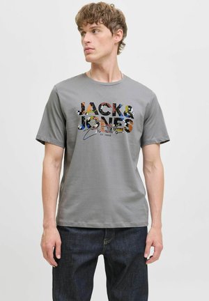 Graues Baumwoll-T-Shirt mit einem mehrfarbigen Grafikdruck auf der Vorderseite, kurzen Ärmeln und rundem Ausschnitt, kombiniert mit dunkler Jeans.