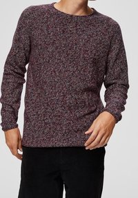 Hnědočervený a šedý žíhaný pletený svetr s kulatým výstřihem, dlouhými rukávy a lemováním na manžetách. Volný střih a viditelná textura.