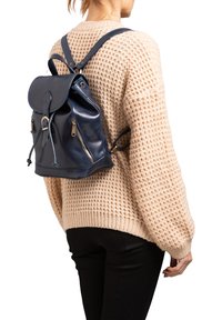 Navy leren rugzak met een trekkoordsluiting, voorflap en twee ritszakken. Voorzien van verstelbare schouderbanden en een zachte textuur.